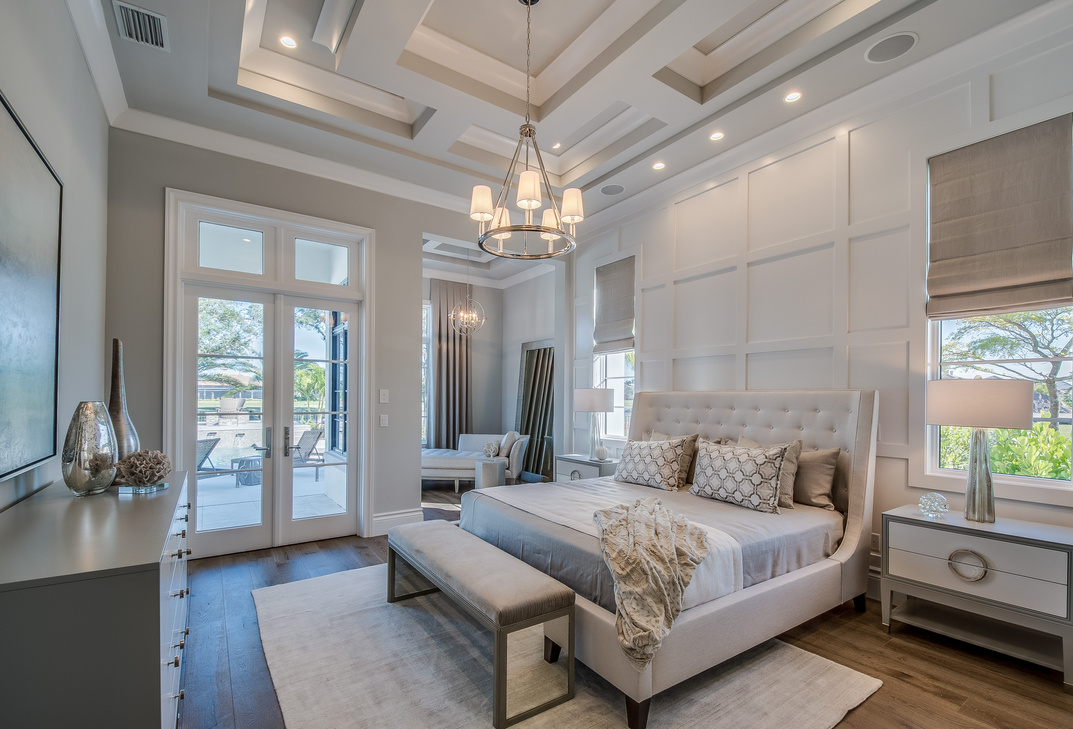 Master bedroom with high coffered ceiling and wainscoting wall